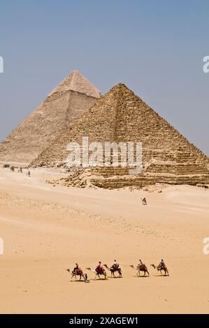 The great Pyramids of Giza with a camel caravan in the foreground . Stock Photo