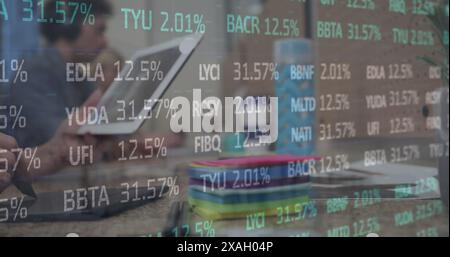 Image of stock market data processing against mid section of a woman using graphic tablet Stock Photo