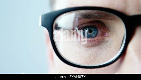 Image of young caucasian male wearing glasses looking intently at something Stock Photo