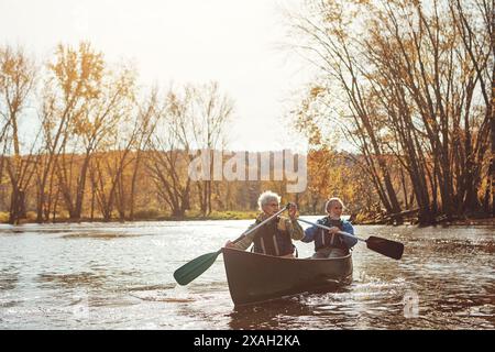 Lake, senior couple and kayaking in nature with canoe for explore, adventure or retirement activity. Outdoor, river and elderly woman with man on boat Stock Photo