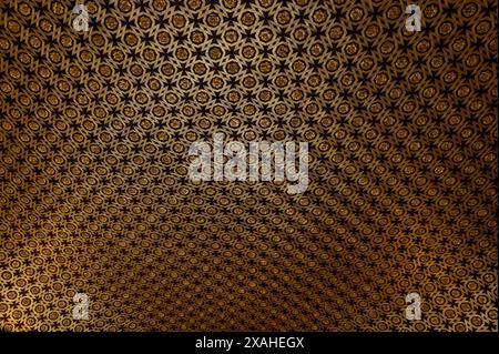 Ornate wooden ceiling with a detailed, repetitive pattern and golden accents from the 16th century in the chapter house of the real alcázar of Sevilla Stock Photo