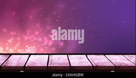 Image of lights over violet background with wooden surface Stock Photo
