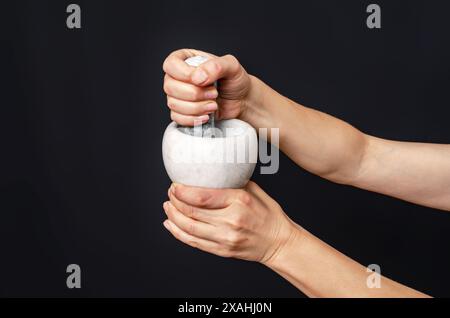 Close up of a pharmacist using mortar and pestle in the pharmacy Stock Photo