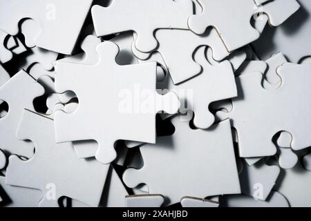 close up of white puzzle pieces stacked in piles Stock Photo