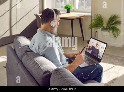 Middle aged man in headphones having conference at home Stock Photo