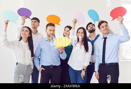 Team of corporate employees with blank thinking and speech bubbles in their hands Stock Photo