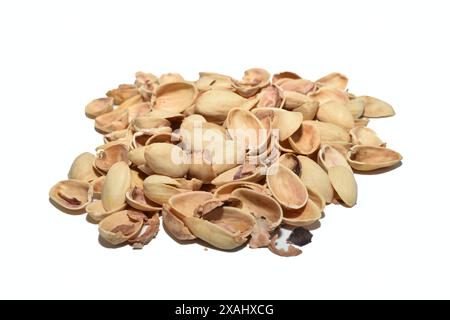 The shells from eaten pistachios lie in a pile on the table. Stock Photo