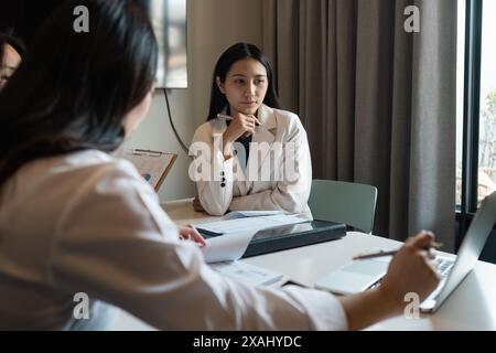 Professional Business Collaboration Meeting in Modern Office Setting with Diverse Team Members Discussing Strategies and Analyzing Data for Successful Stock Photo