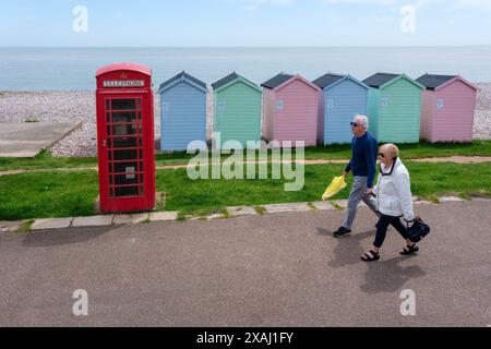 A middle-aged couple walking along the seafront at Budleigh Salterton, Devon Stock Photo
