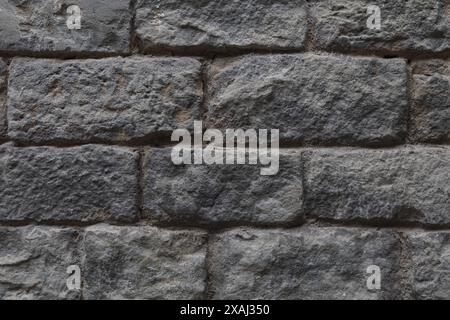 close-up flat photography of an old grey stone brick wall surface, rough ashlar textured background Stock Photo
