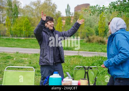 non-binary couple hugging having a picnic in a park. Pride day Stock Photo