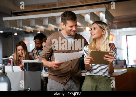Two young businesspeople using a digital tablet while standing in a boardroom. Stock Photo