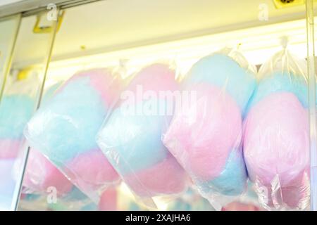 Colorful bags of cotton candy on display at a carnival, pink and Stock Photo