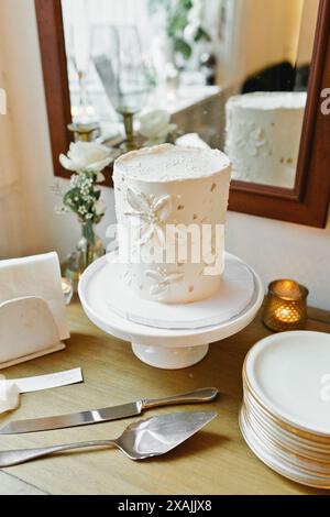 Elegant white floral wedding cake on vintage display Stock Photo