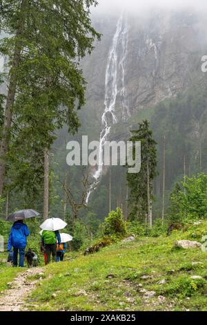 Europe, Germany, Bavaria, Bavarian Alps, Berchtesgaden, Hiking group on a rainy day in front of the Röthbach Falls Stock Photo