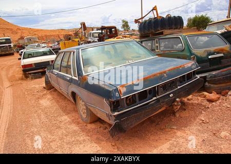 Junkyard of rusty abandoned vintage cars in the desert of the Australian outback of the red center in the opal mining town of Coober Pedy, South Austr Stock Photo