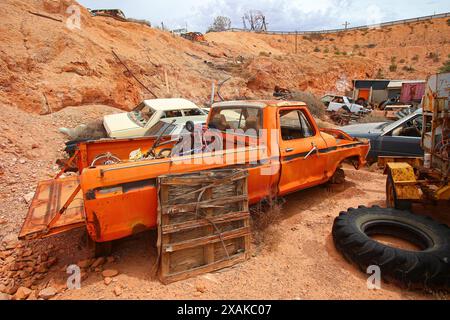 Junkyard of rusty abandoned vintage cars in the desert of the Australian outback of the red center in the opal mining town of Coober Pedy, South Austr Stock Photo