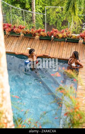 North America, Caribbean, Hispaniola Island, Dominican Republic, Samana Peninsula, Sanchez, Jardines La Loma, Two attractive dark-skinned Latinas chatting in the pool Stock Photo