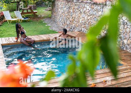 North America, Caribbean, Hispaniola Island, Dominican Republic, Samana Peninsula, Sanchez, Jardines La Loma, Two pretty Latinas sitting in the pool and chatting Stock Photo