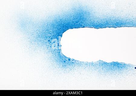White torn paper painted with blue spray paint revealing white background. Space for text. Stock Photo