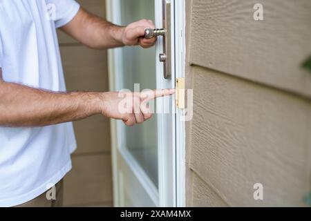 hand ringing on doorbell on pvc front door Stock Photo