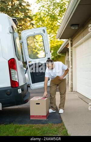 Courier with clipboard near delivery van outdoors Stock Photo
