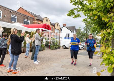 Leeds, UK. 07 JUN, 2024. People cheer on passing runners as they follow 7 mile route, shaped like a rhino, through the streets of Moor town in honour of Leeds Rhinos legend number 7 Rob Burrow, who passed away on Sunday aged 41 following an over 4 year battle with motor neurone disease (MND). Credit Milo Chandler/Alamy Live News Stock Photo