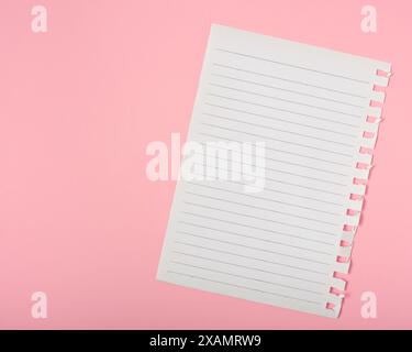 Notebook sheet with stripes on pink background. Stock Photo