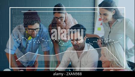 A diverse group of young and middle-aged colleagues is collaborating on project using a computer Stock Photo