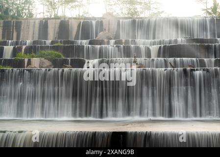 A waterfall with a lot of water and rocks in Grojogan Watu Purbo, Yogyakarta, Indonesia Stock Photo