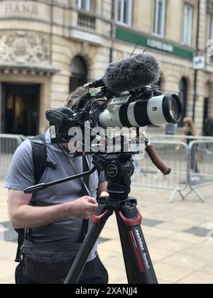 A Channel 4 TV cameraman filming the D-Day parade on Lincoln high street in Lincoln. Lincolnshire, Stock Photo