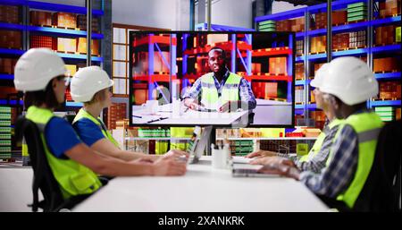 Warehouse Workers Having Video Conference With Man Stock Photo