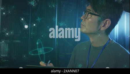 Image of molecule structures, asian man checking data server using digital tablet in server room Stock Photo