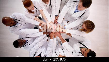 Medical Team Stacking Hands Against In Hospital Stock Photo