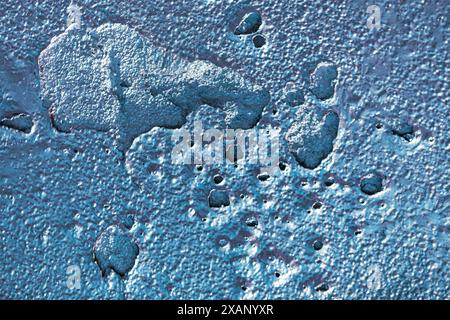 Blue surface with small holes cracks, providing a textured and visually appealing pattern Stock Photo