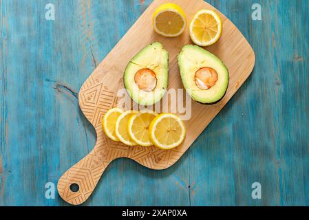 Lemon and avocado, fresh fruit on wooden board Stock Photo