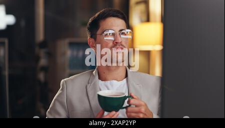 Man, night and computer for business and drinking coffee, reading report and working overtime on startup. Programmer, plan and research on internet Stock Photo