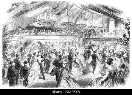 Ball on board H.M.S. Royal Alfred, the flagship of Admiral Sir R. Mundy, at Barbadoes, 1868. Engraving from a sketch by Captain H. J. Wilkinson, Assistant Quartermaster-General. 'At an early hour in the evening boats were conveying the company of ladies and gentlemen to that noble frigate. They ascended her side under a canopy of palm-leaves and flags, when a gay and festive scene presented itself. The spacious deck was covered in with the colours of every nation, forming an elevated ceiling and drooping in graceful festoons on each side. It was brilliantly illuminated by tastefully-decorated Stock Photo
