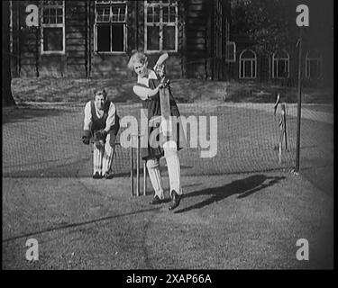 Two Female Civilians Wearing Gymslips and Batting Pads Preparing to Bat in a Playing Field, 1920s. From &quot;Time to Remember - Teenage Flapper&quot;, 1920s (Reel 1); a dcumentary about women's lives in the 1920s - great commentary by Joyce Grenfell. Stock Photo