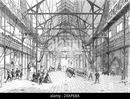 Interior of new Gymnasium in Myrtle-Street, Liverpool, 1865. 'The large hall presents to the eye an array of ladders, bars, ropes, and nets, which to the uninitiated is hopelessly bewildering...Mr. Hulley, the well- known master of athletic sports and exercises, under whose superintendence these arrangements have been completed, has had a most extensive experience both in England and on the Continent; and we may safely say that everything the most accomplished gymnast may desire will here be found...The ladies' classes, and the youths' classes...have been so far very successful...The scene fro Stock Photo