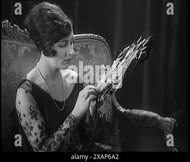 Female Civilian Seating Handling a Fan Made of Feathers, 1920s. From &quot;Time to Remember - Teenage Flapper&quot;, 1920s (Reel 1); a dcumentary about women's lives in the 1920s - great commentary by Joyce Grenfell. Stock Photo