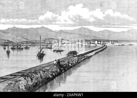 The Abyssinian Expedition: pier and landing-place at Zulla, Annesley Bay, 1868. Engraving from a photograph by Captain Pottinger, Deputy Assistant Quartermaster-General. 'This pier...is about 300 yards long. It has been constructed with great labour; every stone being carried across by the boats from the opposite shore of Annesley Bay. Rails have been laid down to the end of the pier, and trucks are now running to and fro, busily working to convey the vast supplies of commissariat stores and ammunition which are continually being landed here, and several piles of which may be seen on the land, Stock Photo