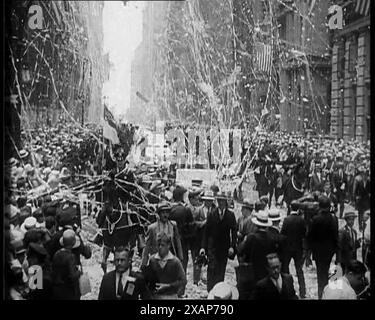 Crowd Watching a Procession, 1933. '...on Broadway there was more paper than rain. Everybody got a great kick out of it'. On 22 July 1933, British aviators Jim Mollison and Amy Johnson took off from South Wales on a non-stop flight to New York, but were forced to crash land in Bridgeport, Connecticut, just short of their target, after running out of fuel. They were both injured, and the plane broken apart by souvenir seekers. From &quot;Time To Remember -  The Time Of The Monster&quot;, 1933  (Reel 2); documentary film about events of 1933, rise of Roosevelt and Hitler. Stock Photo