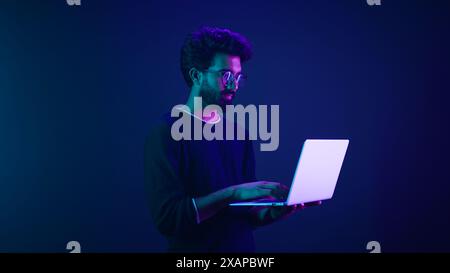 Arabian Indian man guy male programmer coder internet computer developer businessman business guy gamer hold laptop computer invite come here welcome Stock Photo