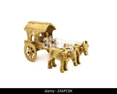 an intricately crafted antique gold model of a vintage bullock cart, used for transport and in agriculture in villages in historical times against a w Stock Photo