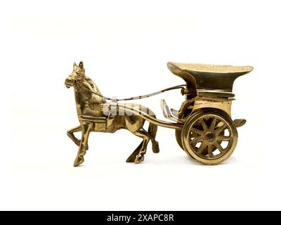 detailed antique model of a horse-drawn carriage used for transportation crafted and intricately designed in golden brass metal isolated on a white Stock Photo