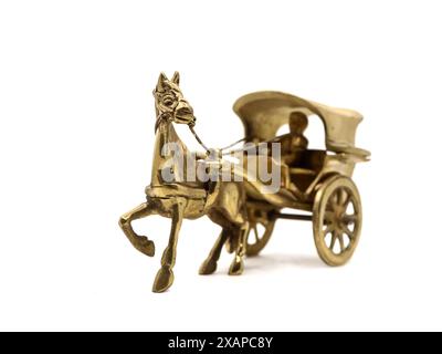 detailed antique model of a horse-drawn carriage used for transportation crafted and intricately designed in golden brass metal isolated on a white Stock Photo