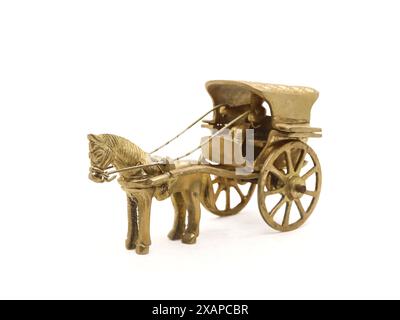 detailed antique model of a horse-drawn carriage used for transportation crafted and intricately designed in golden brass metal isolated on a white Stock Photo