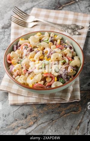 Southwestern pasta salad is a zesty summer side filled with fresh corn, onion, beans, peppers with creamy homemade ranch style dressing closeup on the Stock Photo