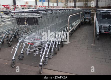 Metal grocery carts stand in a store parking bay Stock Photo